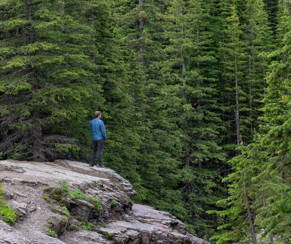 Man standing alone near forest cliff, representing introspection and emotional growth from immature to mature lover