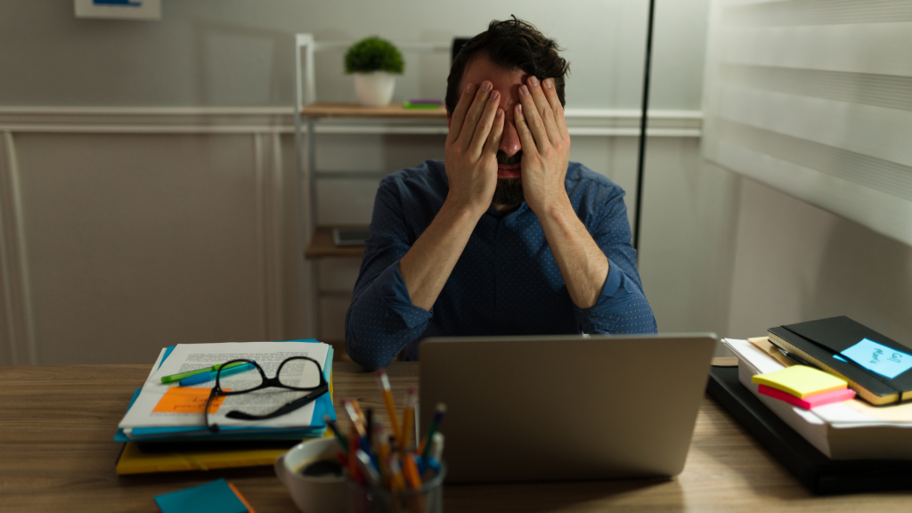 Man feeling stuck at desk trying to Get Motivated, symbolizing lack of energy and focus.
