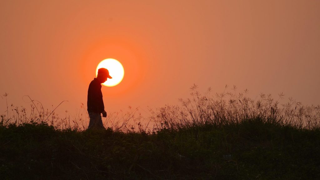 Man walking at sunset symbolizing the connection between vitamin D, mood, and mental health.