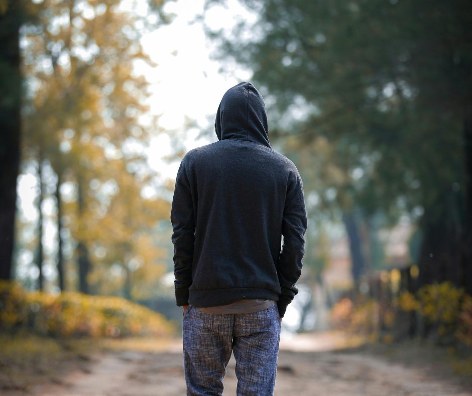 Person walking alone outdoors — representing isolation, reflection, and the need for general mental health support