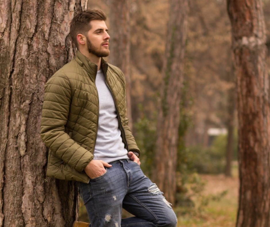 Man standing alone in a forest reflecting — representing men's mental health and the need for support